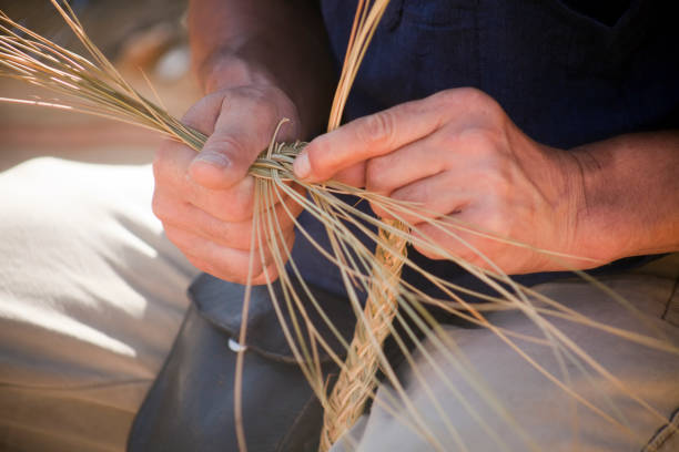 Close-up view of craftsman's hands doing wickerwork.