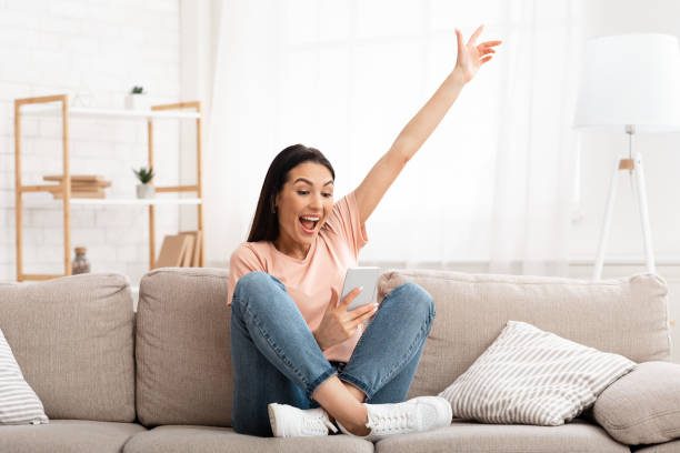 istock Girl celebrating victory online using cell phone 1227503280