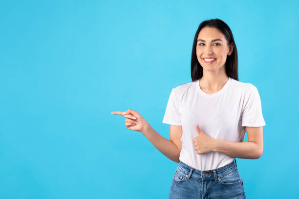 istock Happy woman pointing fingers aside at copy space 1227503459