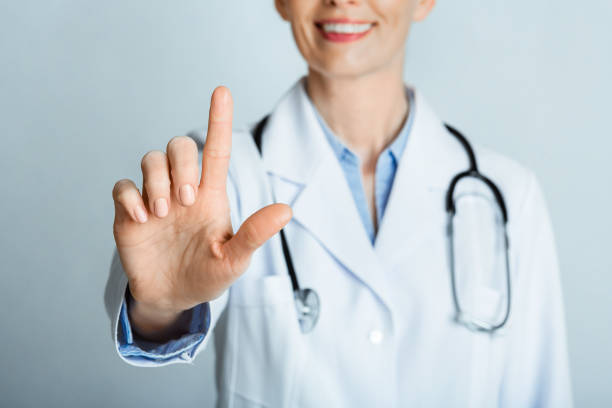 istock Smiling female doctor presses virtual button on the screen. 1227503983