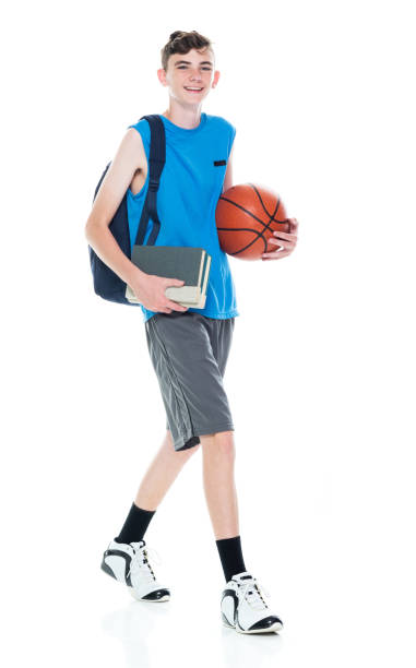 istock Caucasian boys university student walking in front of white background wearing backpack and holding textbook and using sports ball 1227504034
