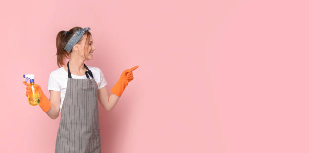 istock Spring Cleaning Offer. Professional Housemaid In Apron Pointing At Copy Space 1227505813
