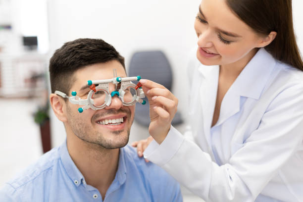 istock Optometrist checking patients vision with trial frame at clinic 1227508507