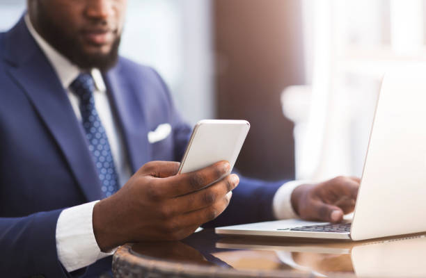 istock Unrecognizable African Entrepreneur Using Cellphone Working In Cafe In City 1227509237