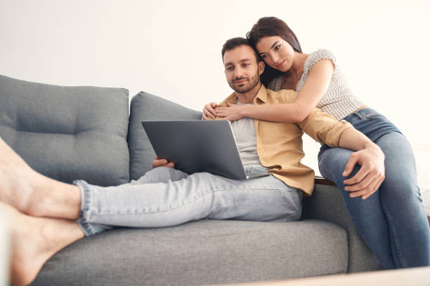 istock Happy young couple in love hugging on a couch 1227512281