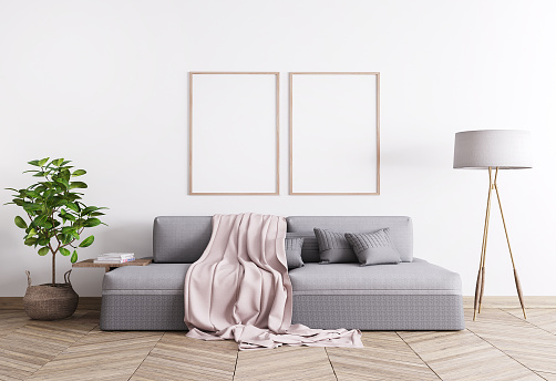 Grey comfortable couch, rattan pot and floor lamp in white template interior mock up,Two A3 wooden frames, stylish home stock photo