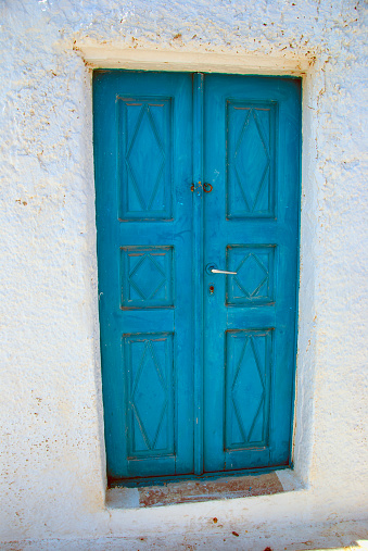 Blue wooden door in white house, Santorini island, Greece