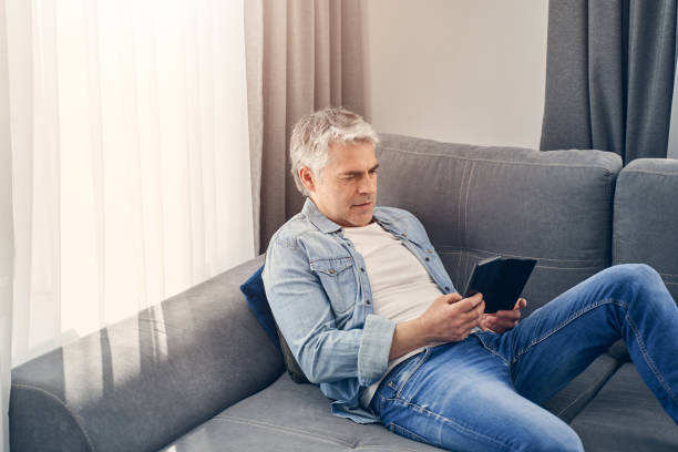 istock Grey haired man sitting on sofa and relaxing 1227514605