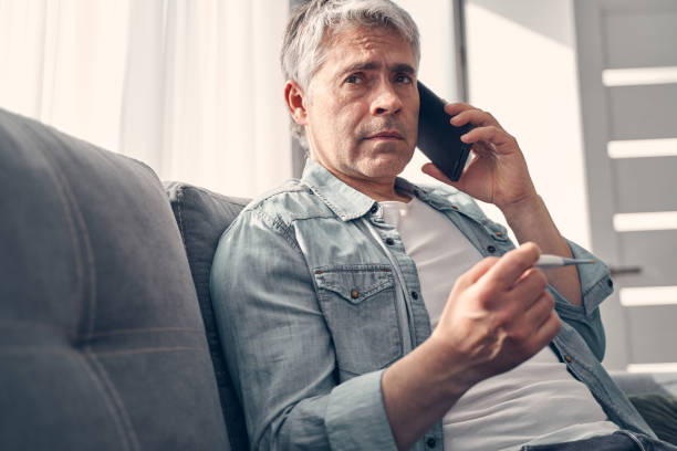 istock Exhausted Caucasian man talking on phone at home 1227514786
