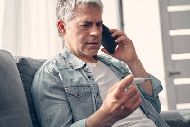 istock Grey haired man talking on phone at home 1227514792