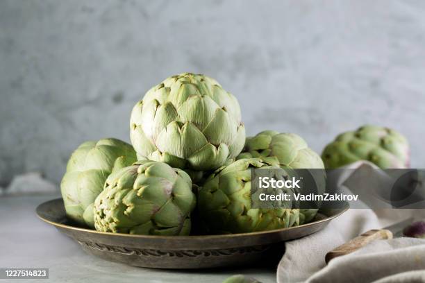 Pile Of Green Spanish Or Italian Artichokes On The Metal Rustic Plate And Gray Background Stock Photo - Download Image Now
