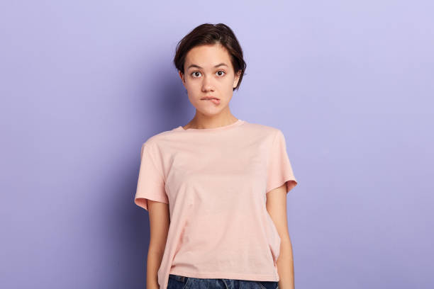 istock girl with white t-shirt and jeans having indecisive confused expression 1227516355