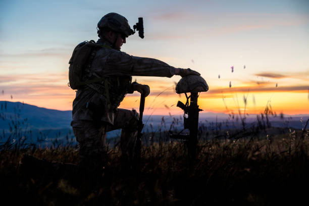 istock Sad Soldier Kneeling for Honoring His Fallen Friend 1227518859