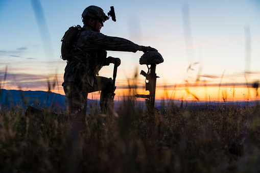 Sad Soldier Kneeling for Honoring His Fallen Friend