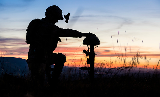 Sad Soldier Kneeling for Honoring His Fallen Friend