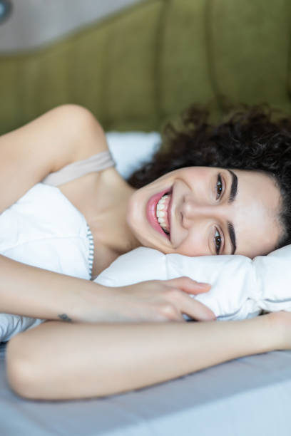istock Smiling woman lying in her bed in bright bedroom 1227520321