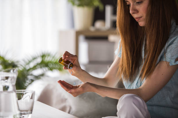 istock Young woman pouring pills into her hand 1227520322