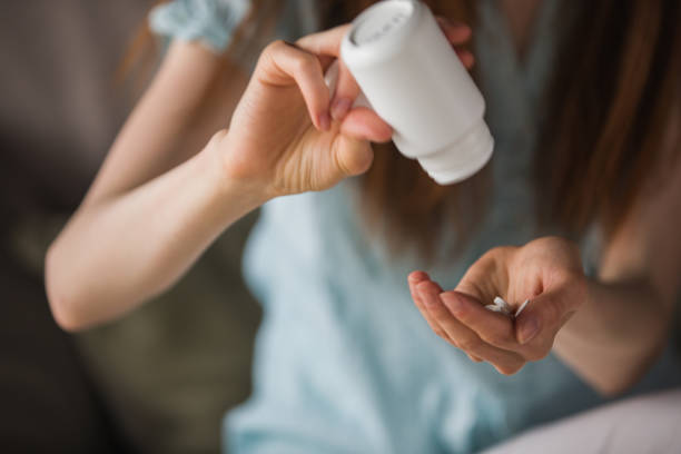 istock Woman pouring pills 1227520345