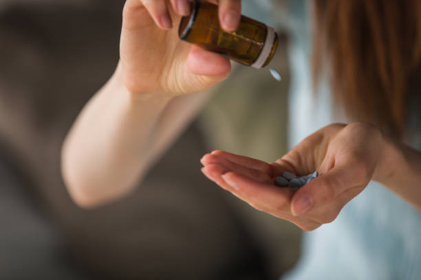 istock Woman pouring pills 1227520347