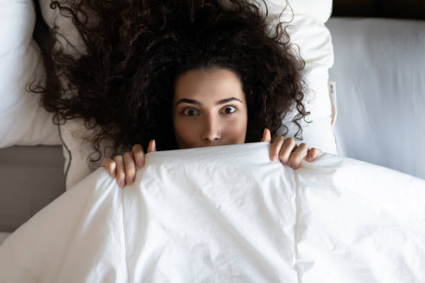 istock Smile woman lying in bed under blanket after wake up 1227520364