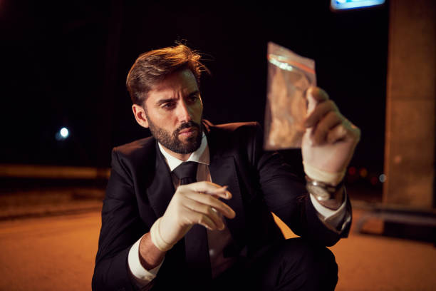istock Curious forensic detective looking at the evidence he found at the crime scene 1227520693