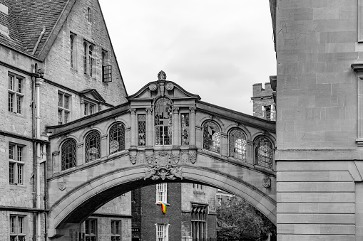 Exterior Of The Bridge Of Sighs In Oxford, Oxfordshire, England, UK. With a rainbow LGBTI flag isolated in colour under the bridge.