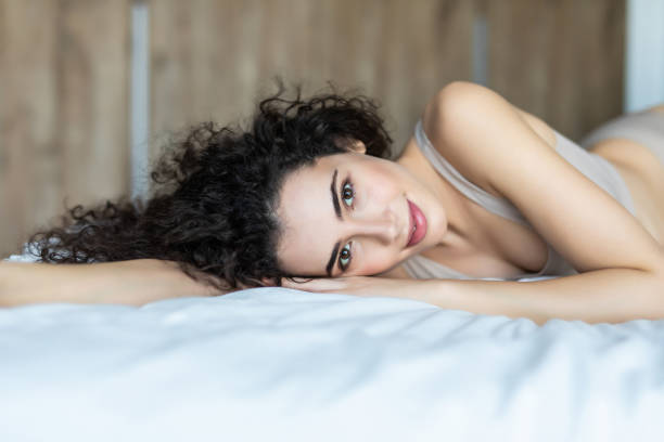 istock Smiling woman lying in her bed in bedroom 1227524231