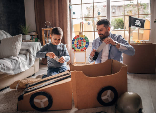 istock Father and son playing car racing with cardboard boxes 1227525236
