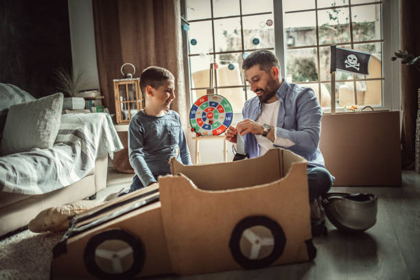istock Father and son playing car racing with cardboard boxes 1227525310