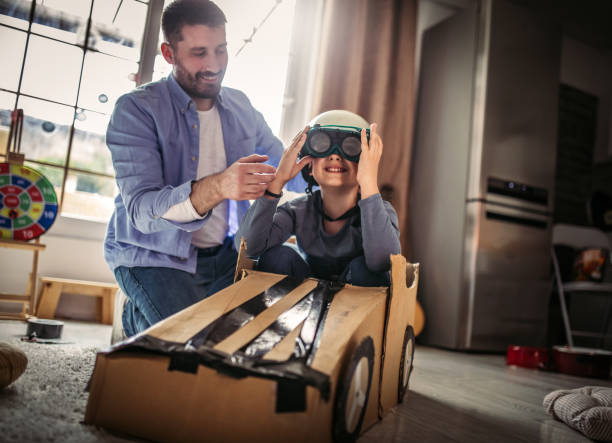 istock Father and son playing car racing with cardboard boxes 1227525327