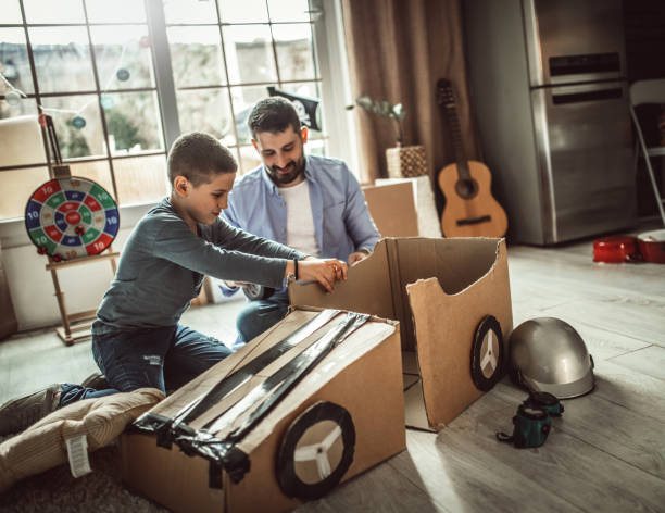 istock Father and son playing car racing with cardboard boxes 1227525330