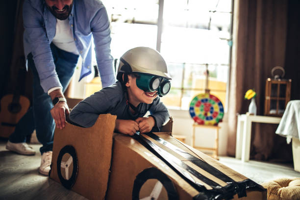 istock Father and son playing car racing with cardboard boxes 1227525517