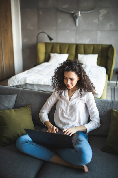istock Happy pretty woman using laptop sitting on sofa 1227526533