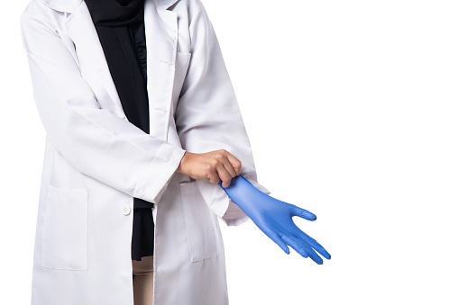 Healthcare & Medicine and Disease & Prevention concept of female laboratory medical researcher in white coat putting on protective gloves, studio shoot concepts.