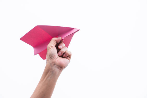 istock Hand throwing yellow paper airplane 1227531782