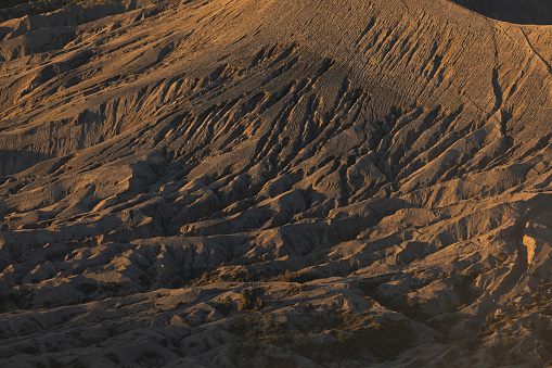 Sunrise, close-up of the dunes and hillsides that surrounds the active volcano Bromo, in the Tengger massif, in East Java, Indonesia.
