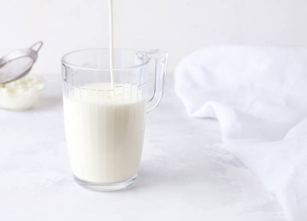 istock Fermented milk drink kefir is poured into a glass on a white background. 1227533873