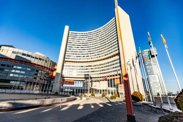 Photo of UN building in Vienna, Austria with flags on a sunny day against the sky. Horizontal orientation