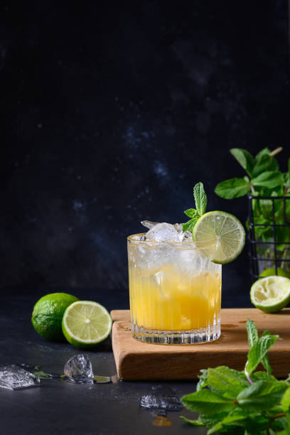 Freshness tropical lemonade with lime, orange and mint on black. Vertical format. Freshness tropical lemonade with lime, orange, ice cube and mint on black. Vertical format. mai tai stock pictures, royalty-free photos & images