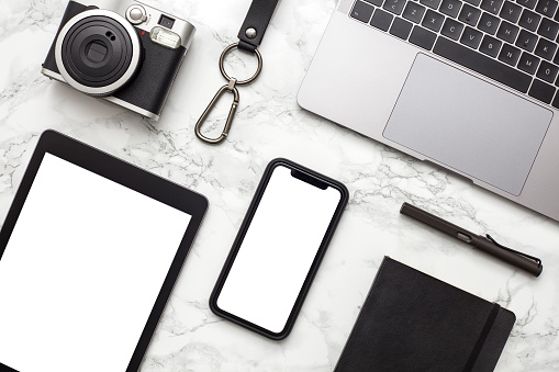 Mockup of smartphone with white screen on marble textured background. Flat lay, top view workspace stock photo