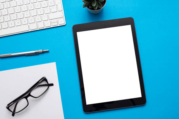 istock Home office desk workspace with mockup of digital tablet, computer, glasses, succulent on color background. Flat lay, top view modern minimalist blog hero header template. stock photo 1227537644
