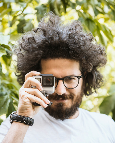 Close up portrait of photographer holding an action camera, selective focus