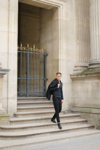 istock Young man walking on concrete stairs, metal gate in background 1227539400