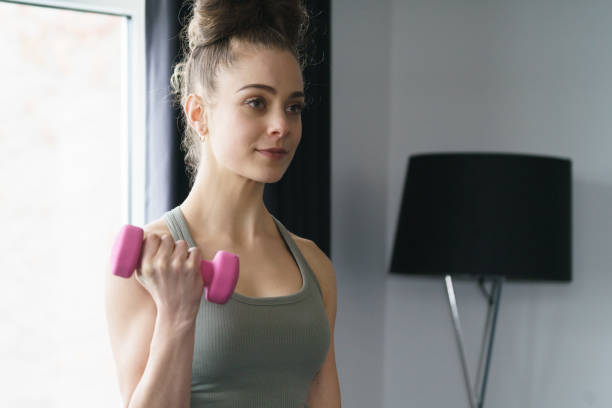 istock Young girl doing indoor exercise workout at home 1227539881