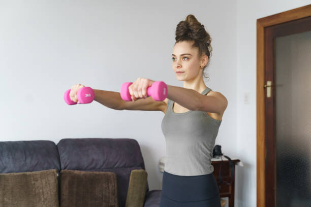 istock Young girl doing indoor exercise workout at home 1227539883