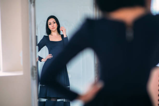 istock Young beautiful woman looking in mirror 1227541374