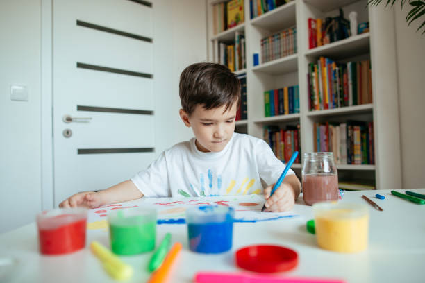 istock Cute 5 year old preschooler boy draws with left hand. 1227543869