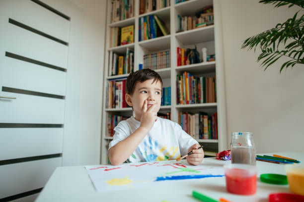 istock Preschooler looking for inspiration while painting. 1227543947
