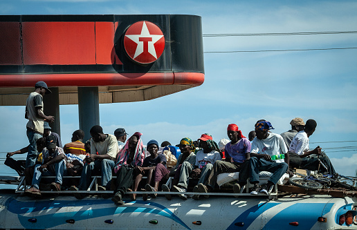 Cap-Haïtien, Haiti - January 12, 2009 : Passengers on the roof of the bus. Haiti is recognized as one of the poorest countries on Earth. More than 80 per cent of the population lives below the poverty line.