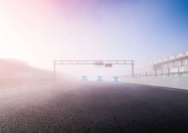 Photo of Speed cars at the start line with green light signal on. Cars ready to start on a speed circuit. Morning fog on the race circuit track. Fast cars with the lights off. Ready set go. Race Drive Concept